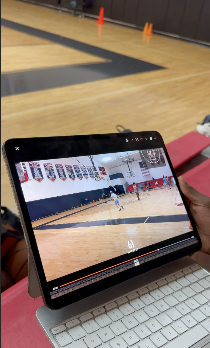 Young athlete reviewing game footage on a tablet with a mentor