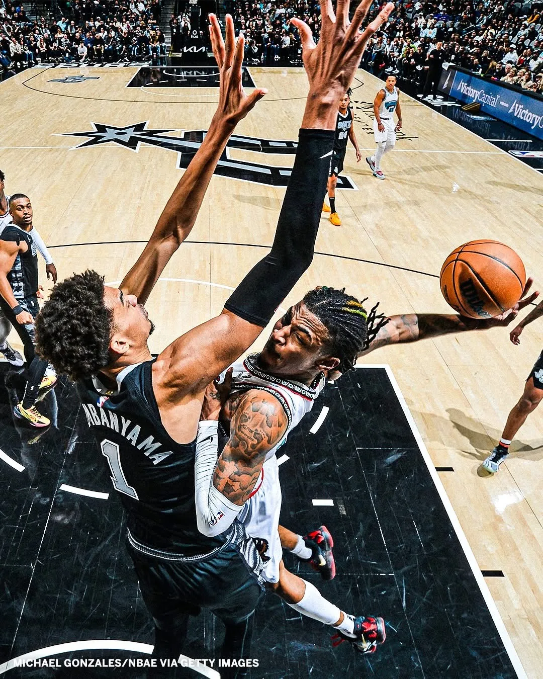 Two basketball players contesting a shot at the rim